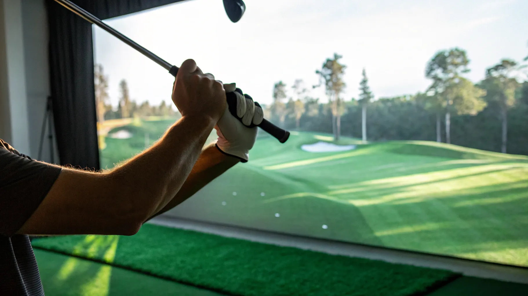 Golfer analyzing their golf swing speed on a monitor app indoors.