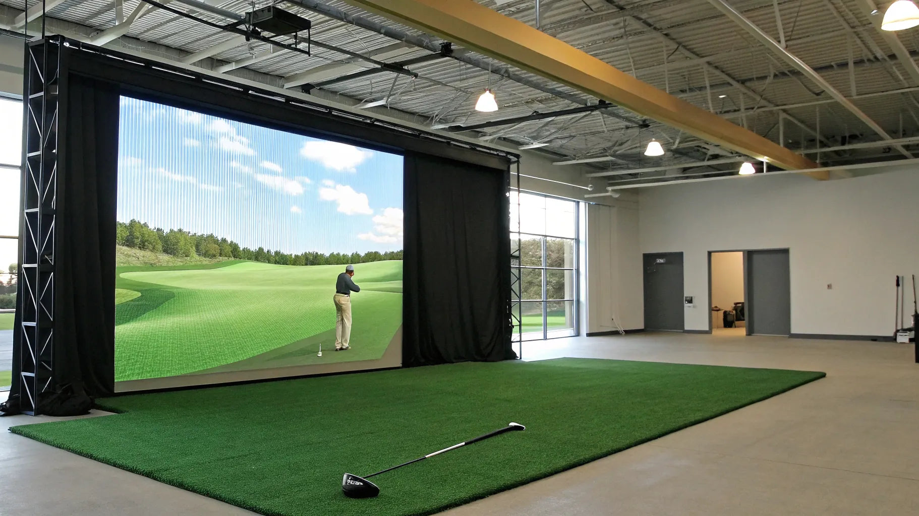 A professional commercial golf simulator installation inside a dedicated indoor golf room.