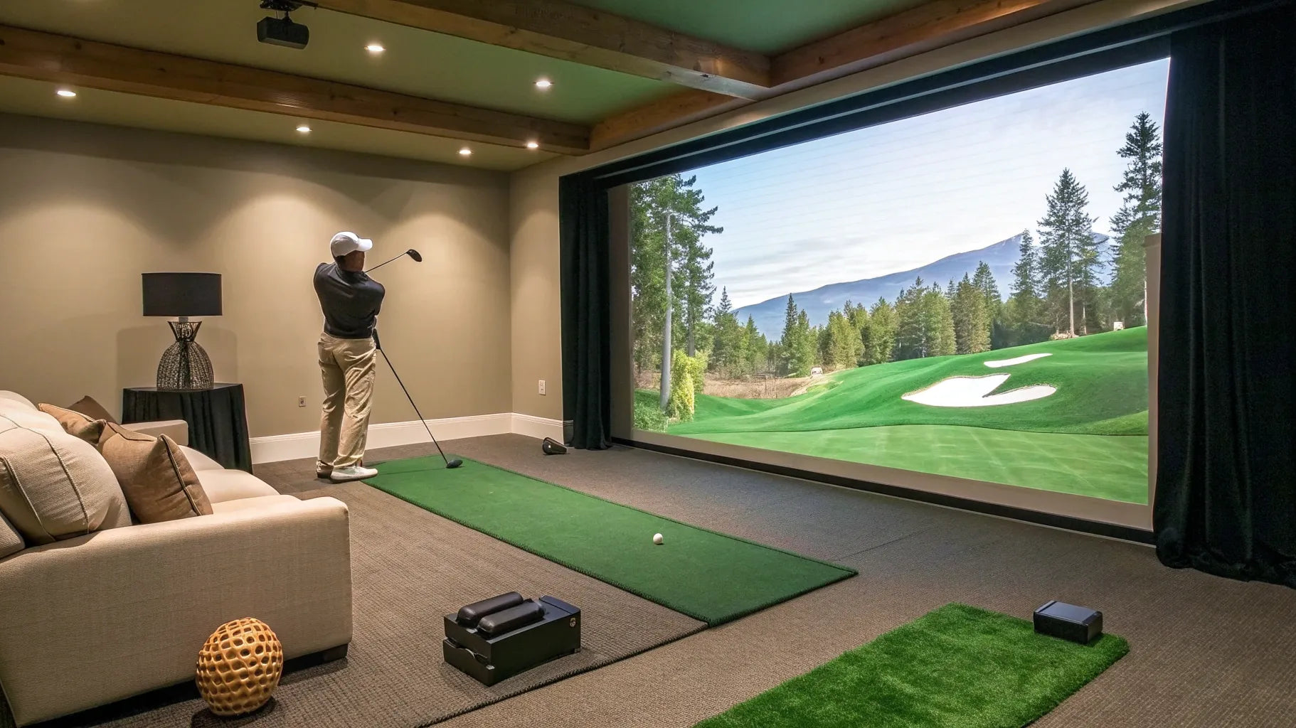 A man uses a golf simulator for indoor use, complete with a hitting mat and large screen.