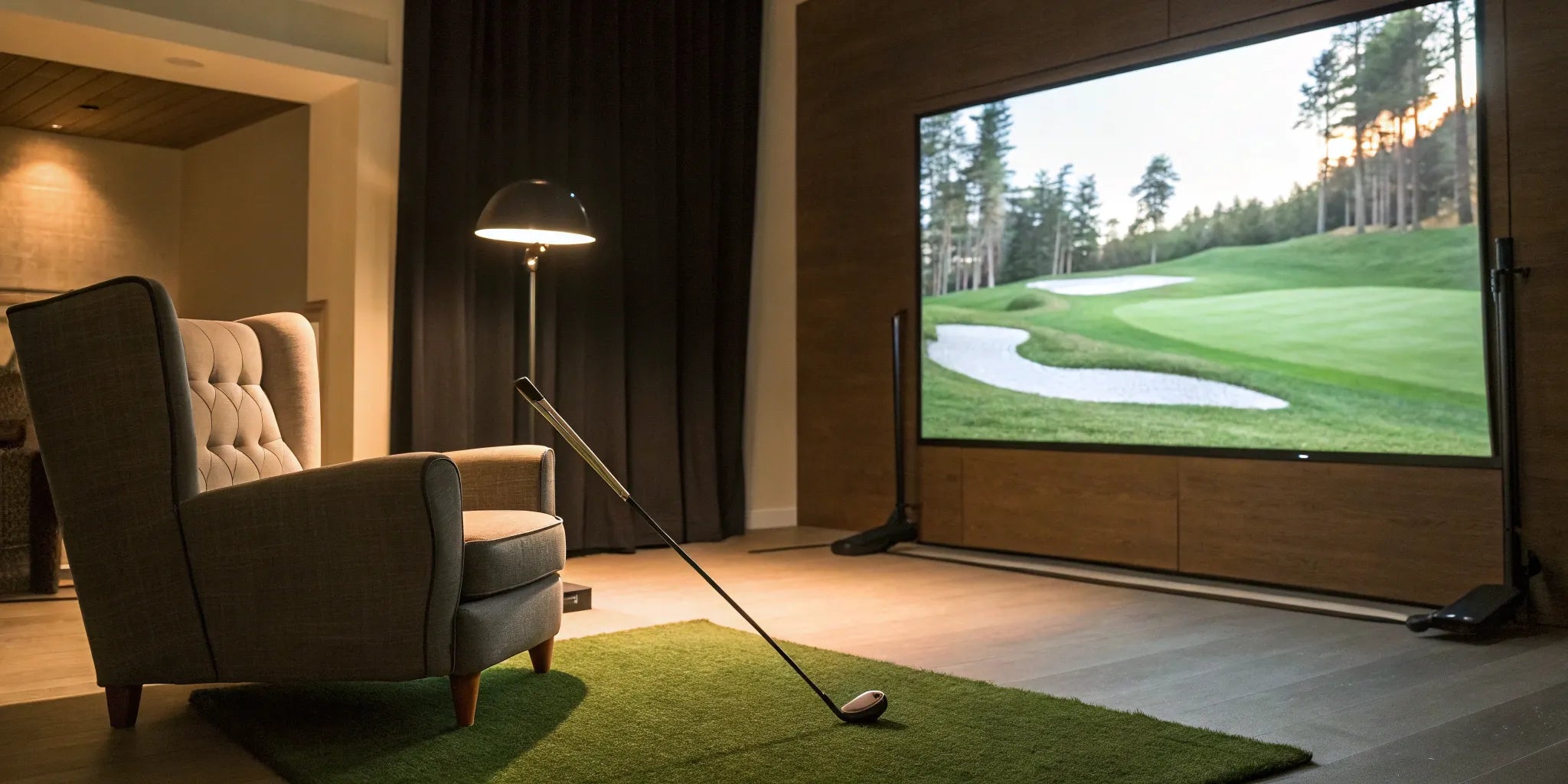 A home golf simulator with a large impact screen, projector, and turf hitting mat.