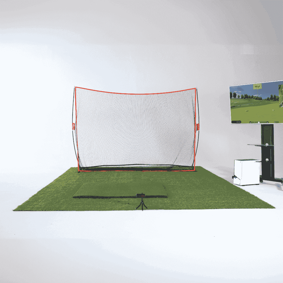 Golf practice net on a green mat with a TV displaying a golf course in the background.