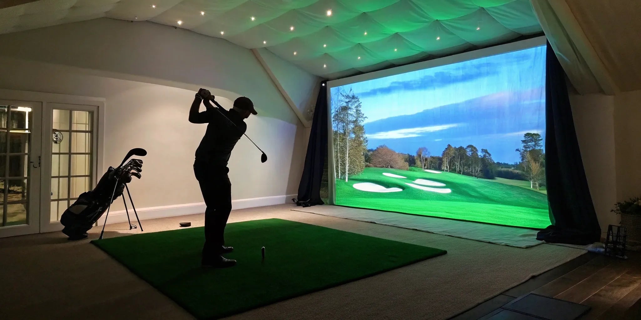 A golf simulator projector under $500 displays a bright, clear image of a fairway on a screen.